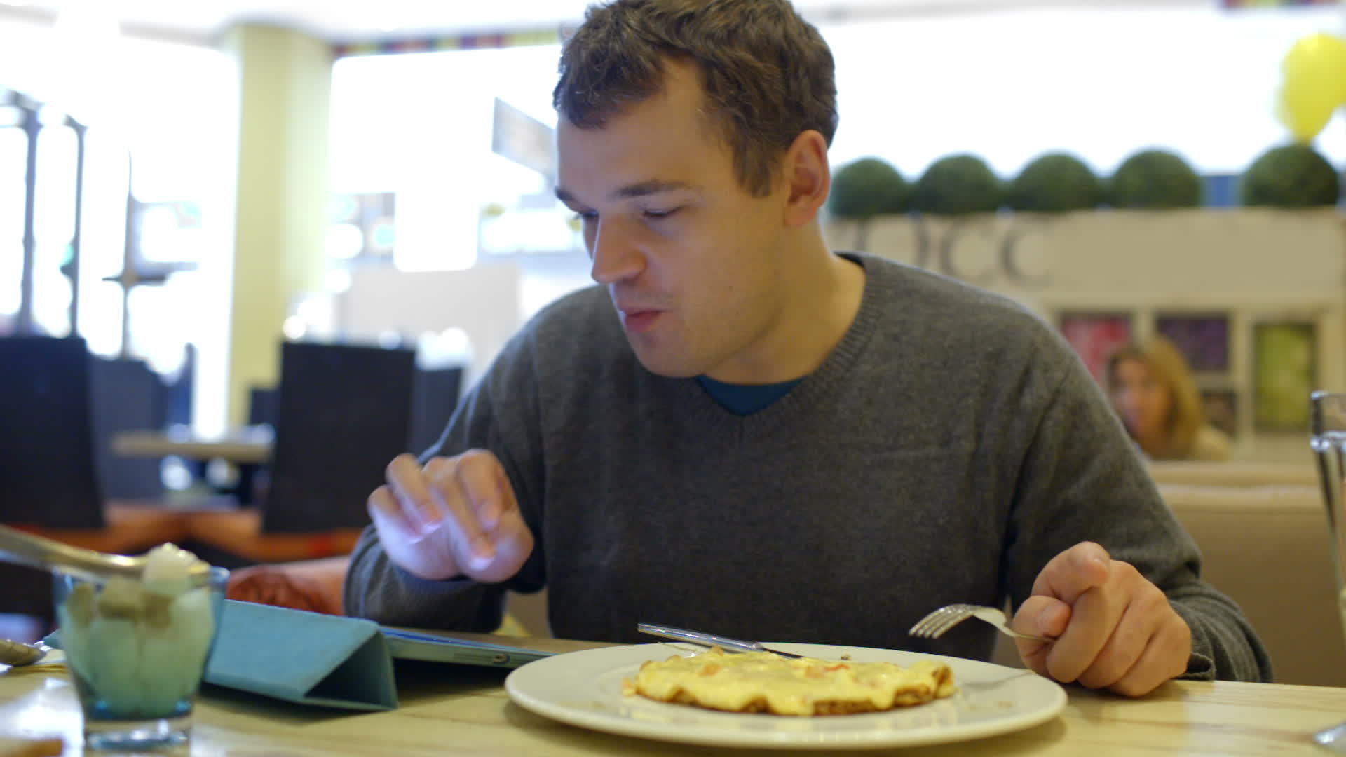 男人在咖啡馆吃饭用平板电脑吃饭视频的预览图