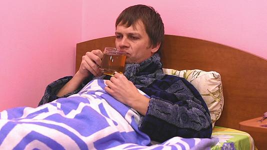 一个躺在床上喝热茶的病人视频的预览图