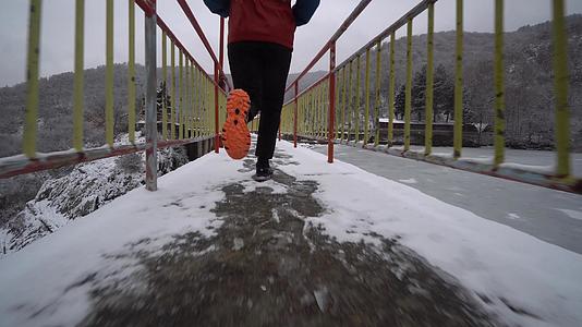 冬天人们在冰冻的湖边的桥上慢跑视频的预览图