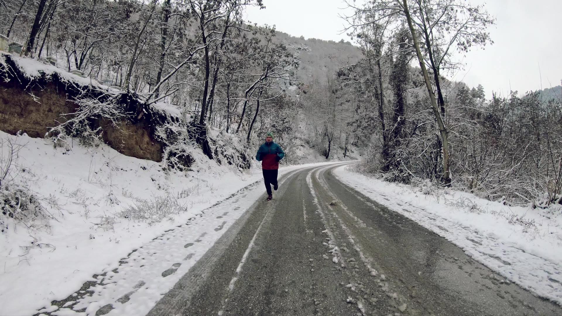 一个人在寒冷的冬天在雪地里慢跑慢慢地在户外慢跑视频的预览图