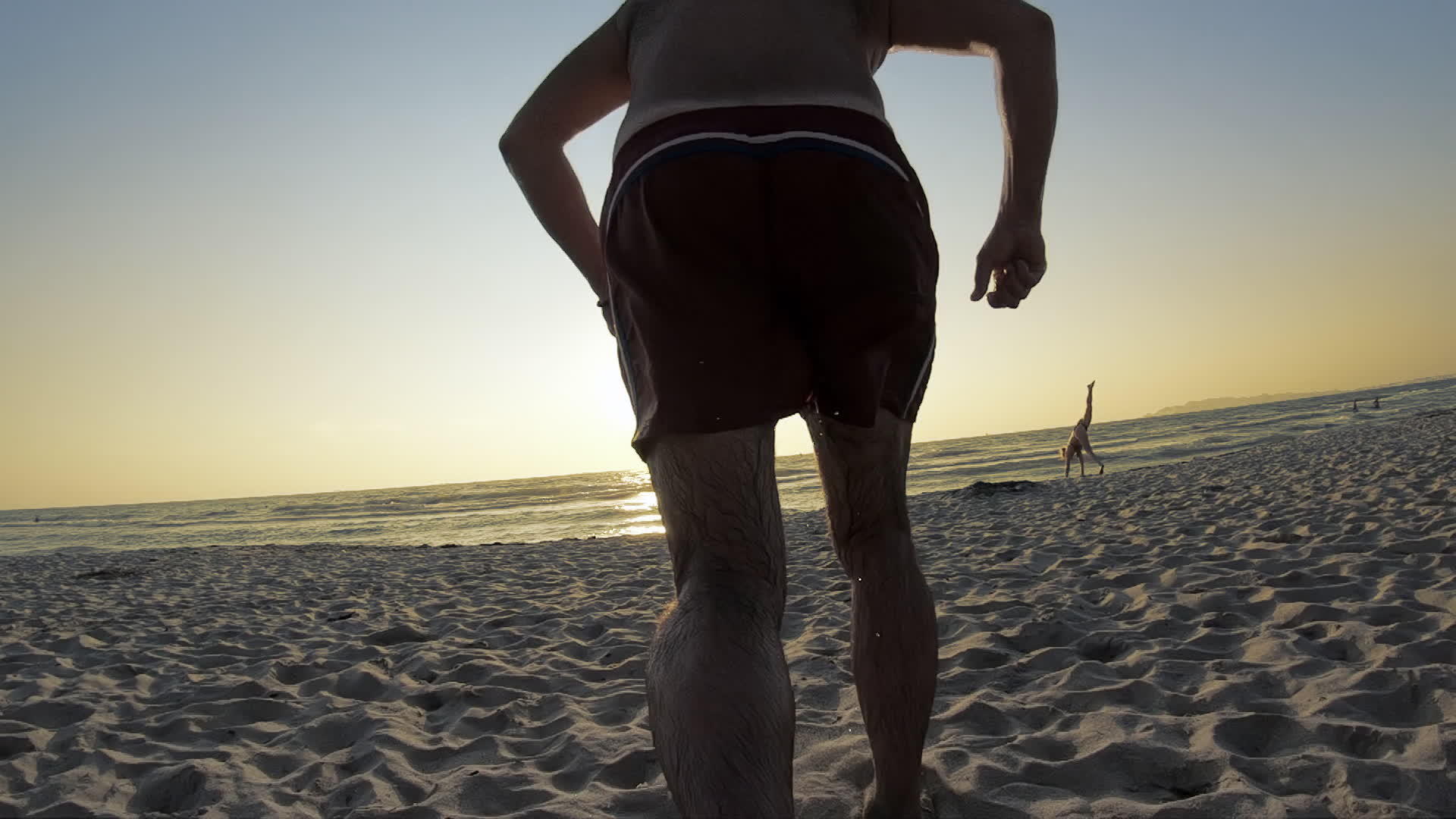 人类在海滩上奔向海洋日落缓慢视频的预览图
