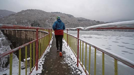冬天 在冰冻的湖边雪桥上奔跑视频的预览图