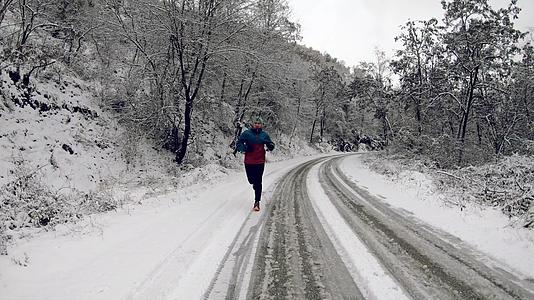 在乡间路上慢跑的人在寒冷的冬天下雪 慢慢移动视频的预览图