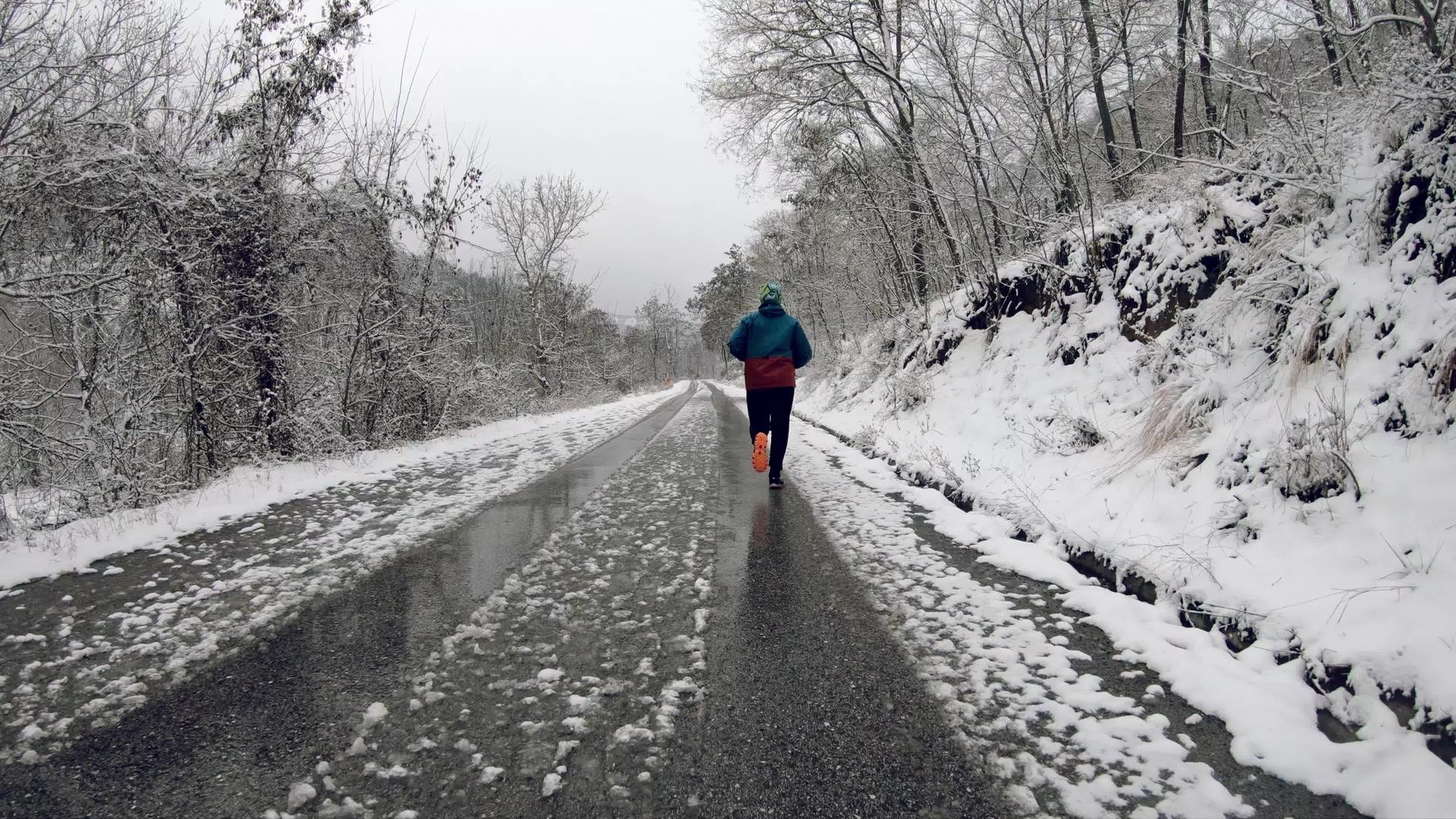 在冬天的森林里男人们在农村的道路上慢慢地运动视频的预览图