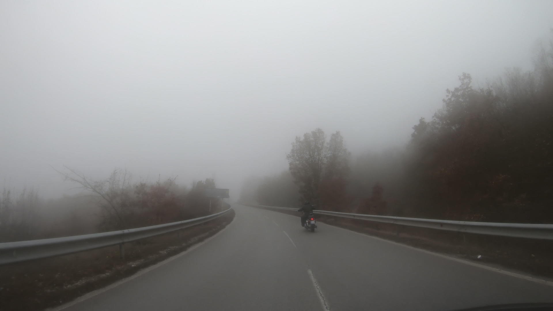 英俊的年轻人骑自行车在恶劣天气下骑摩托车到户外带雾视频的预览图