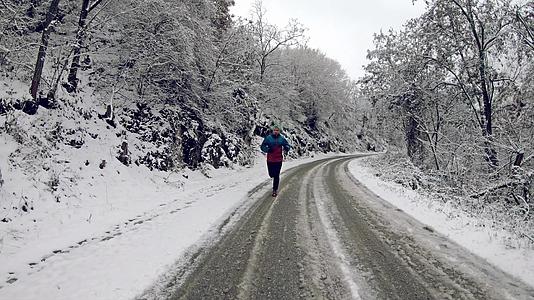 星期天早上穿着冬季夹克的男子在雪地覆盖的乡村道路上视频的预览图