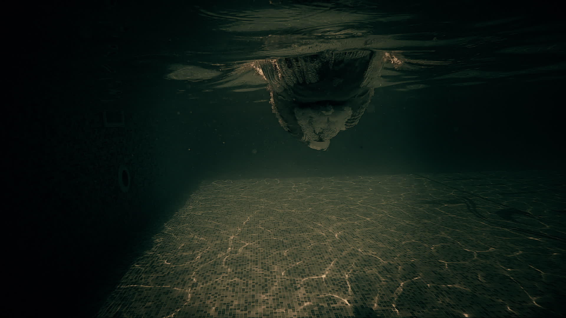 在黑暗和戏剧性的夜晚男人的头在游泳池里跳动视频的预览图