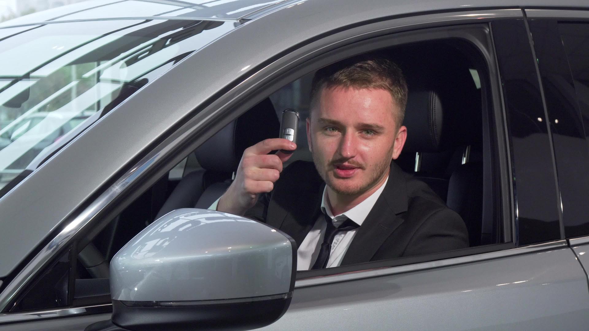 开着车钥匙坐在经销商的一辆新车上商人很兴旺汽车也很兴旺视频的预览图