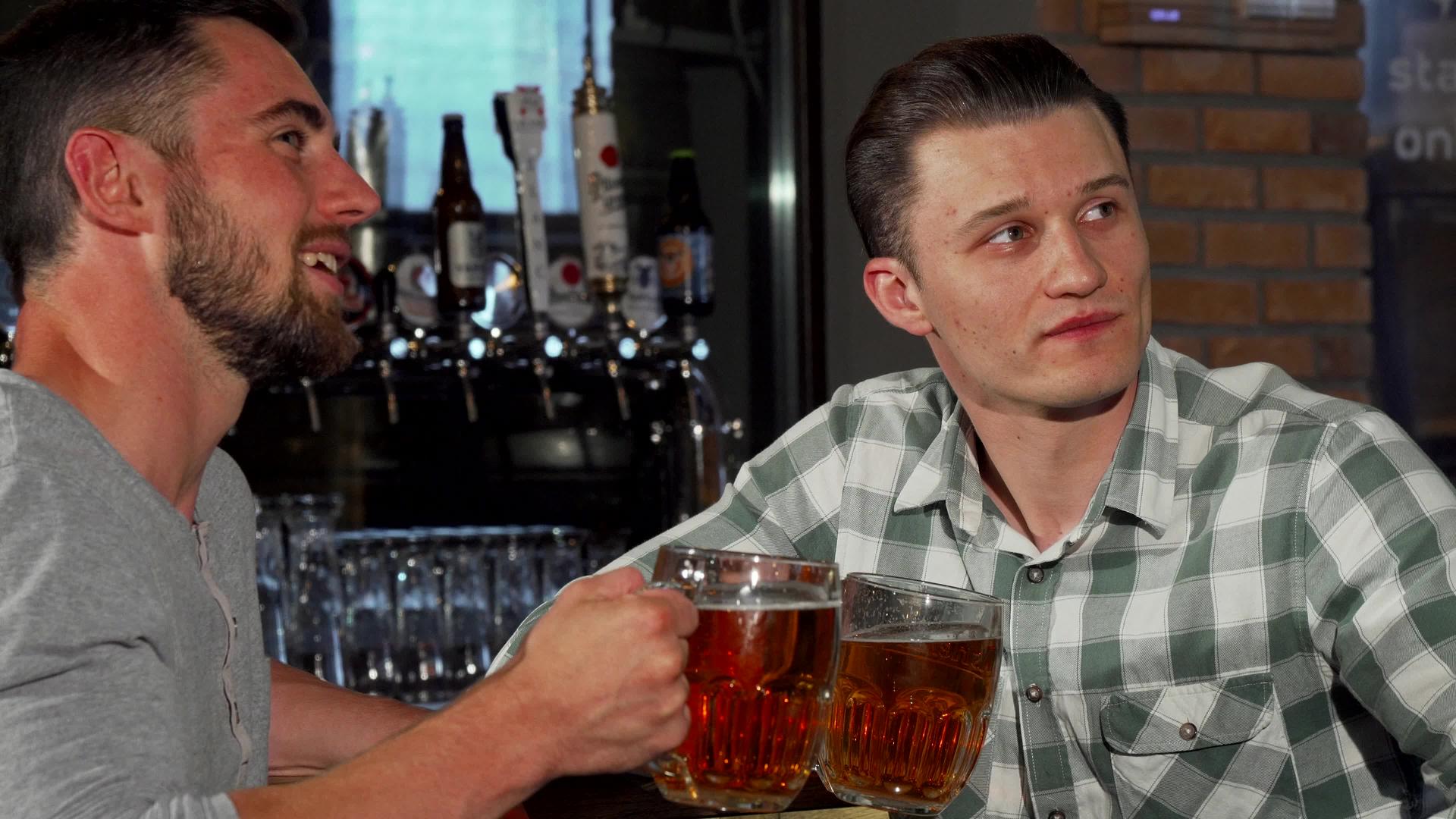 快乐的男性朋友在酒吧看比赛时喝啤酒视频的预览图
