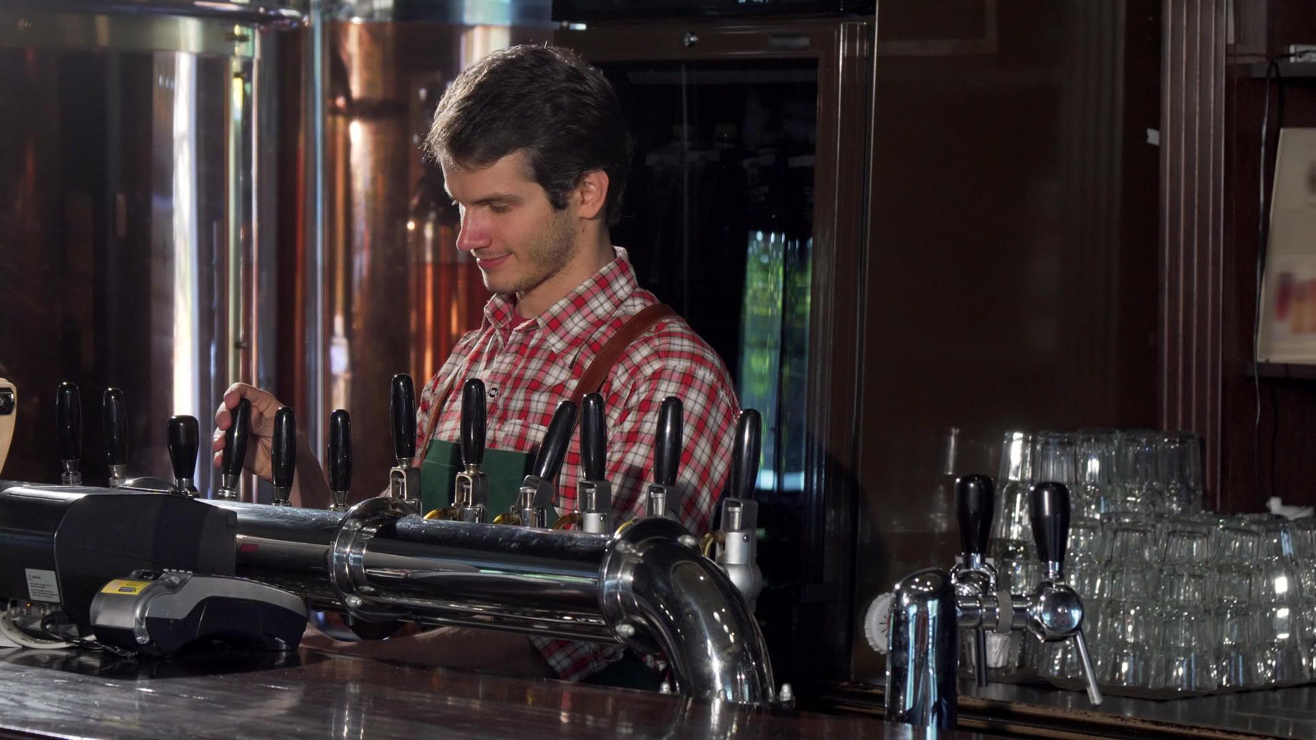男酒保在酒吧里倒酒提供美味的手工啤酒视频的预览图