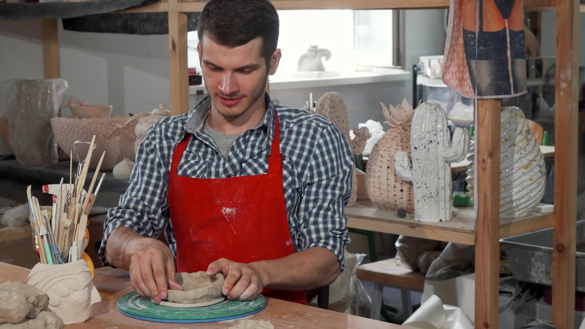 年轻的男性陶瓷艺术家在工作时对相机微笑视频的预览图