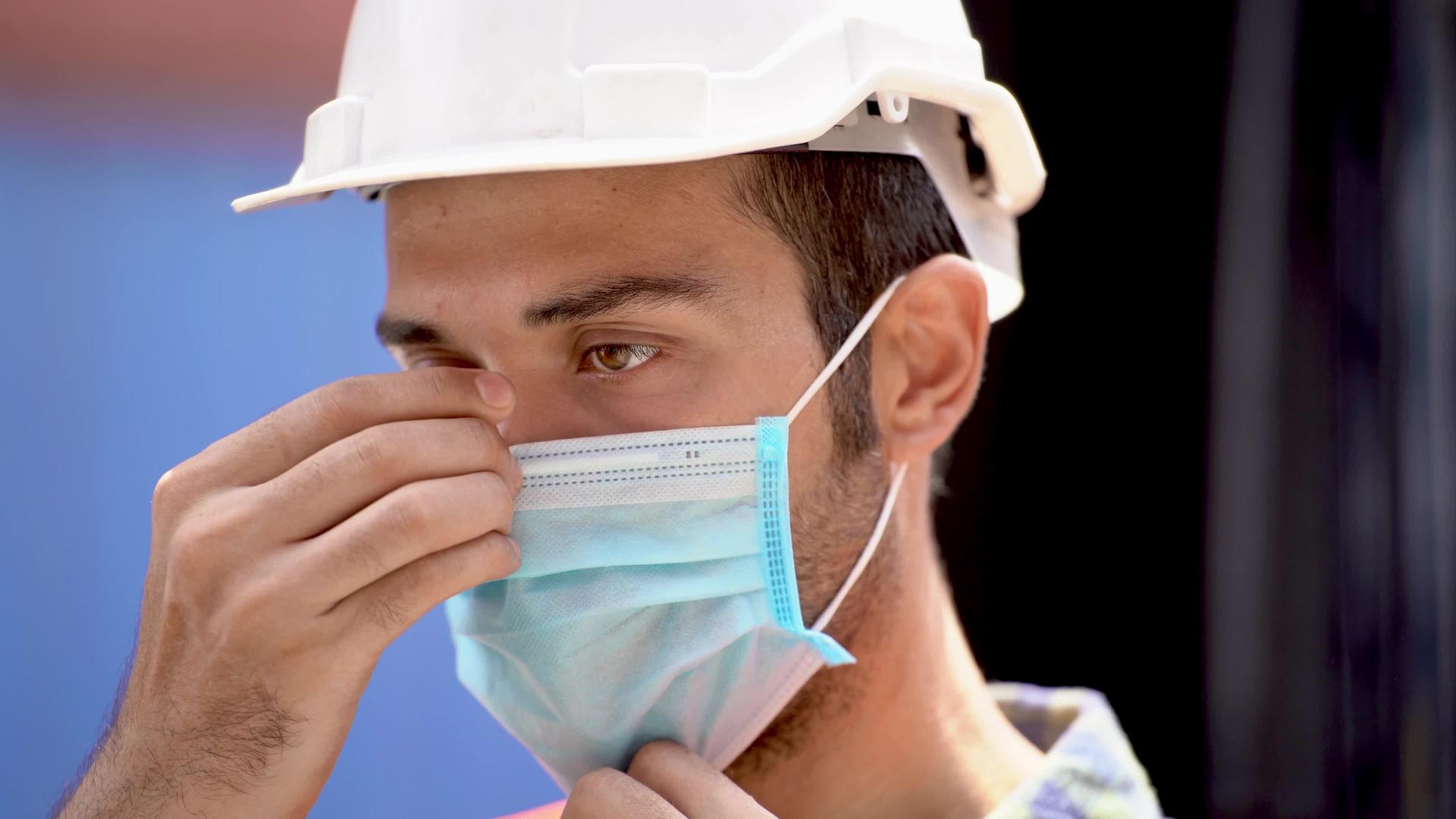 工人在室外仓库工厂佩戴防护口罩和安全帽安全行业工人视频的预览图
