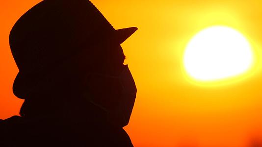 日出日落背景上戴着医用面具的家伙一个戴着美丽风景的家伙视频的预览图