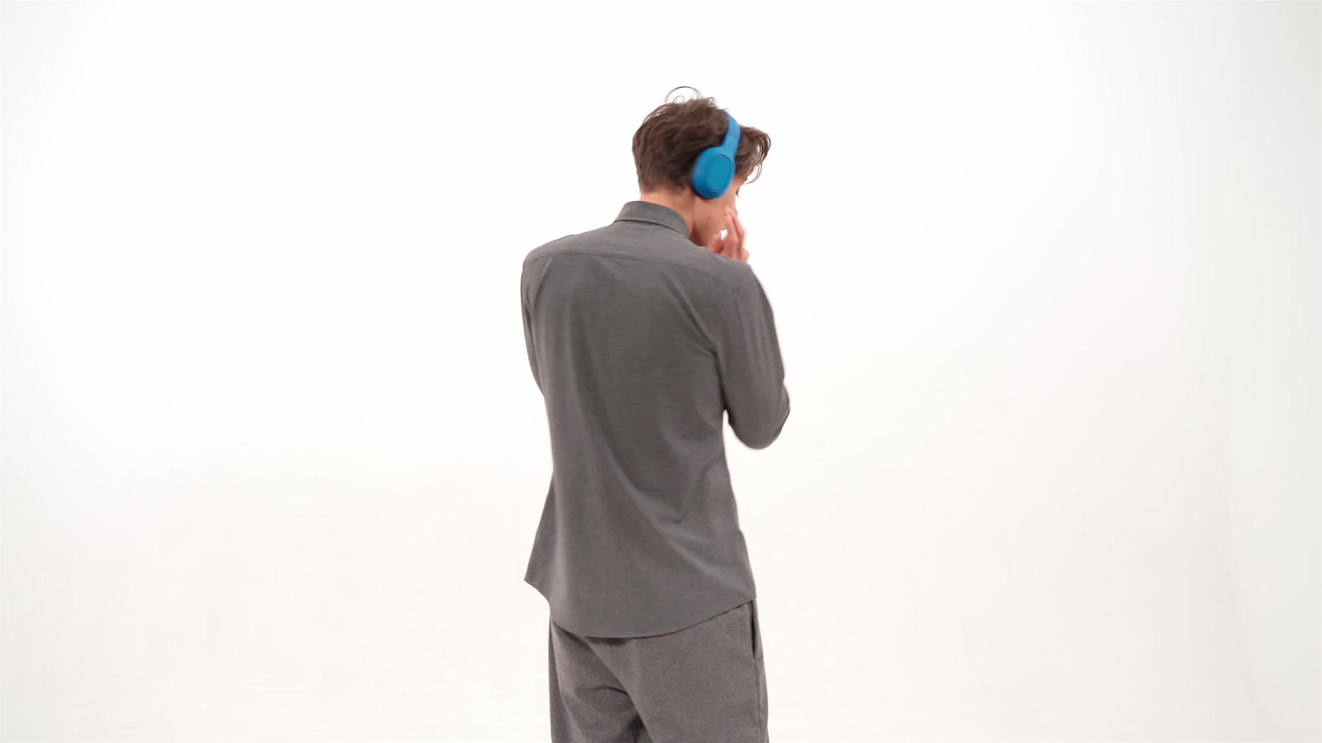 站在镜头前跳舞听音乐穿着灰色运动服戴着蓝色无线耳机视频的预览图