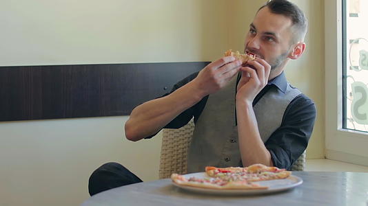 英俊的顾客在披萨咖啡馆吃披萨视频的预览图