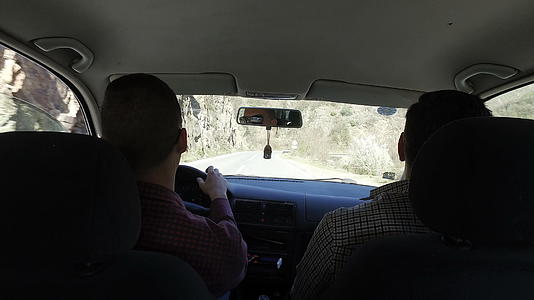 两个人在农村公路上开车旅行他们驾驶汽车并进行愉快的正面旅行视频的预览图