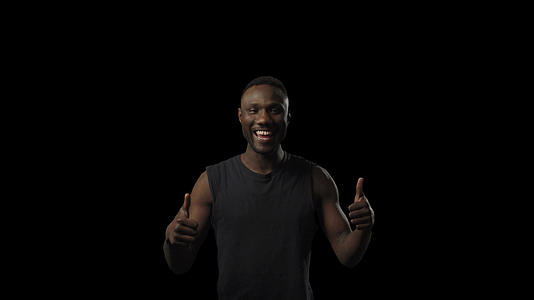 年轻的黑人男子用牙齿微笑着举起两个拇指视频的预览图