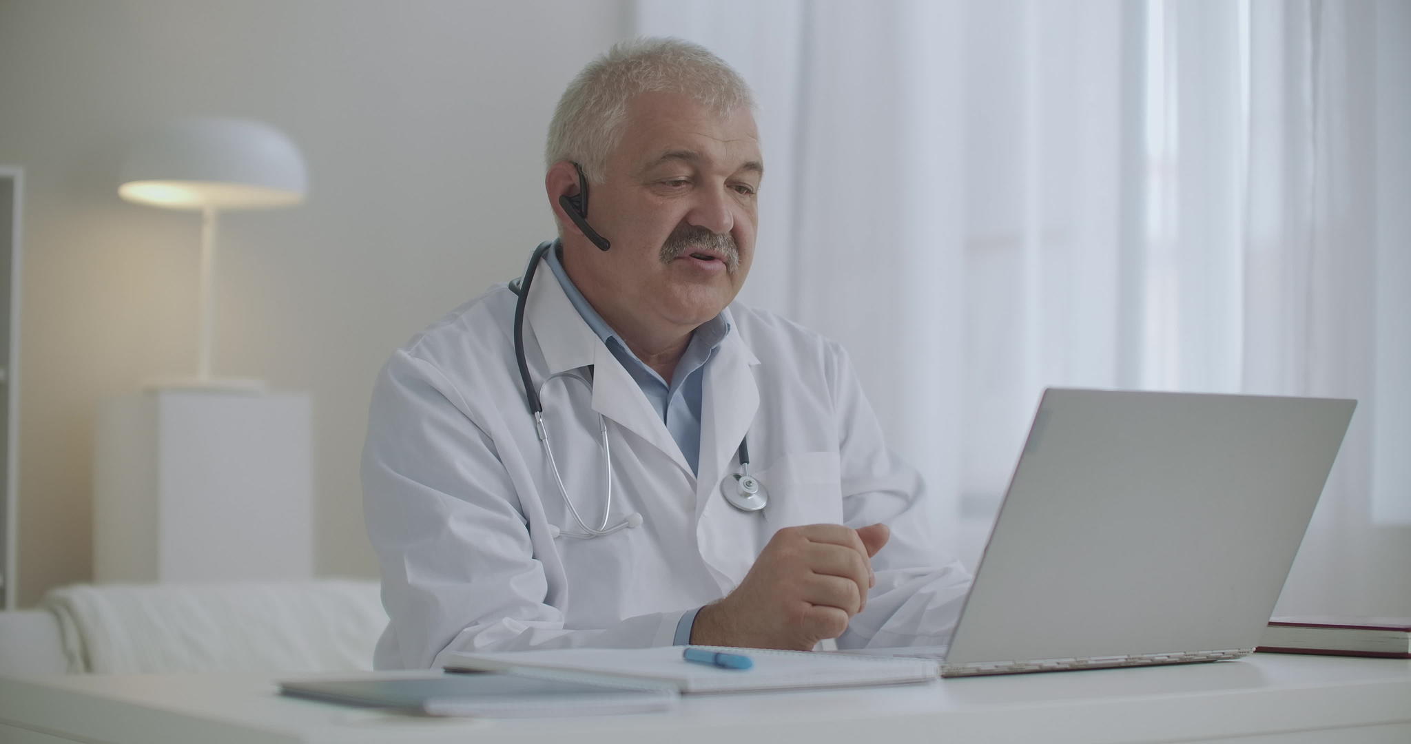 男医生通过笔记本电脑与同事或患者在线交流并使用笔记本电脑视频的预览图