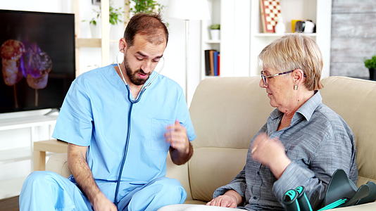 护理医院的男医生在疗养院听老妇人的心跳视频的预览图