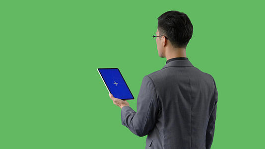 4k绿幕蓝幕合成抠像穿西装的商务男性使用平板电脑背影视频的预览图