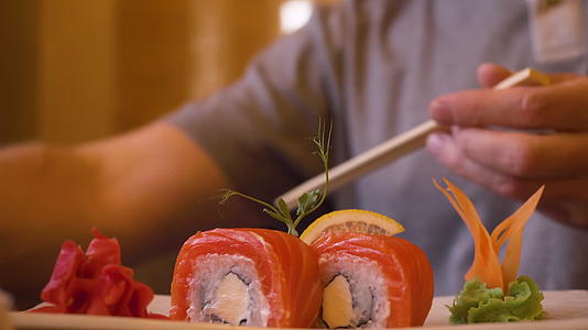 男人在日本餐馆吃寿司卷时用手对着棍子视频的预览图