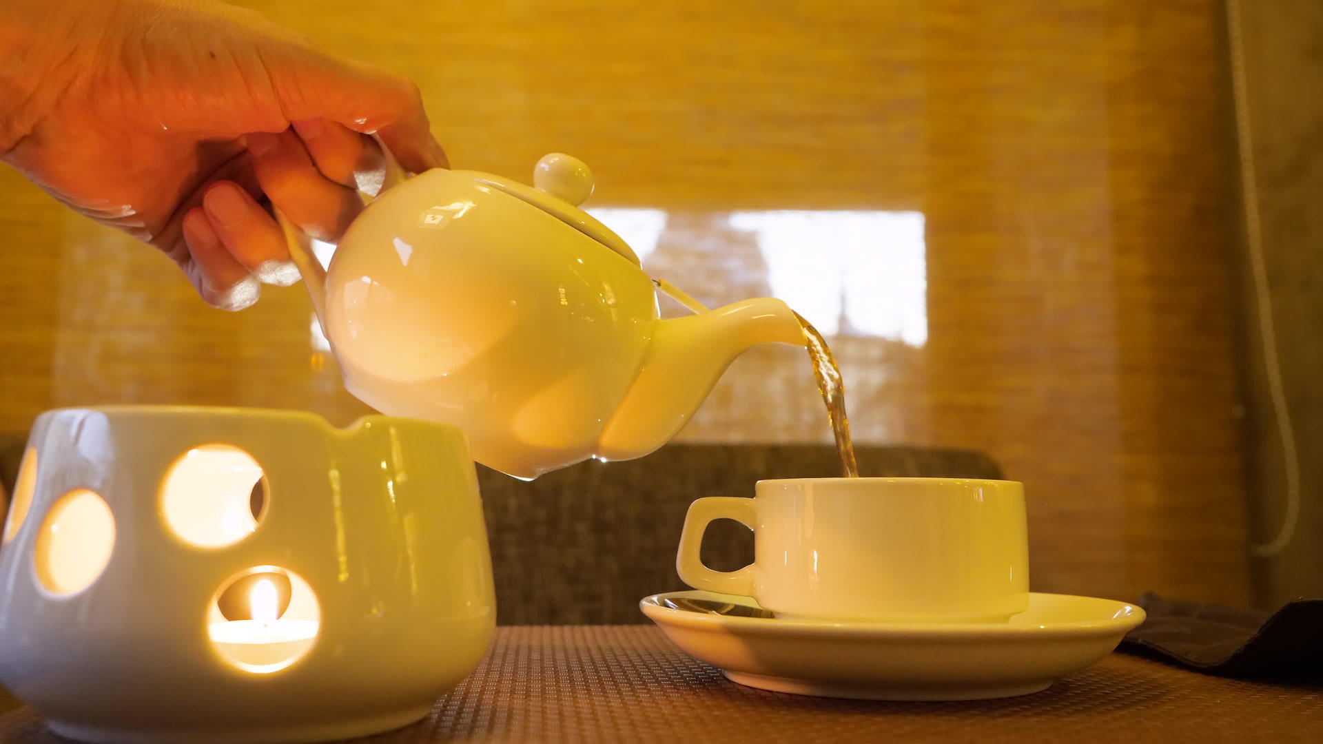 雄手站在蜡烛上喝水关上茶杯倒热茶视频的预览图