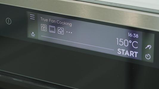 烹饪的男厨师设定了烤箱烘焙的温度视频的预览图