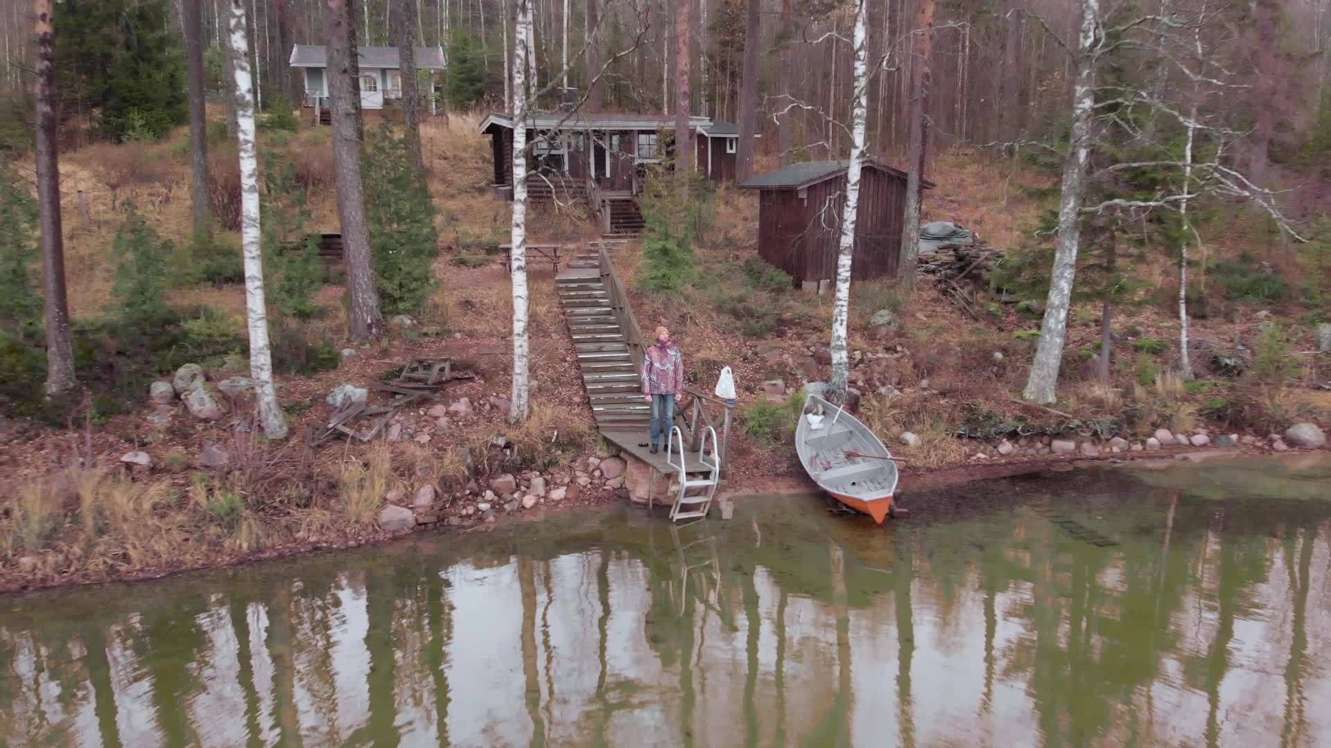 站在芬兰湖边的海边停泊在底座上的人们的空气中视频的预览图