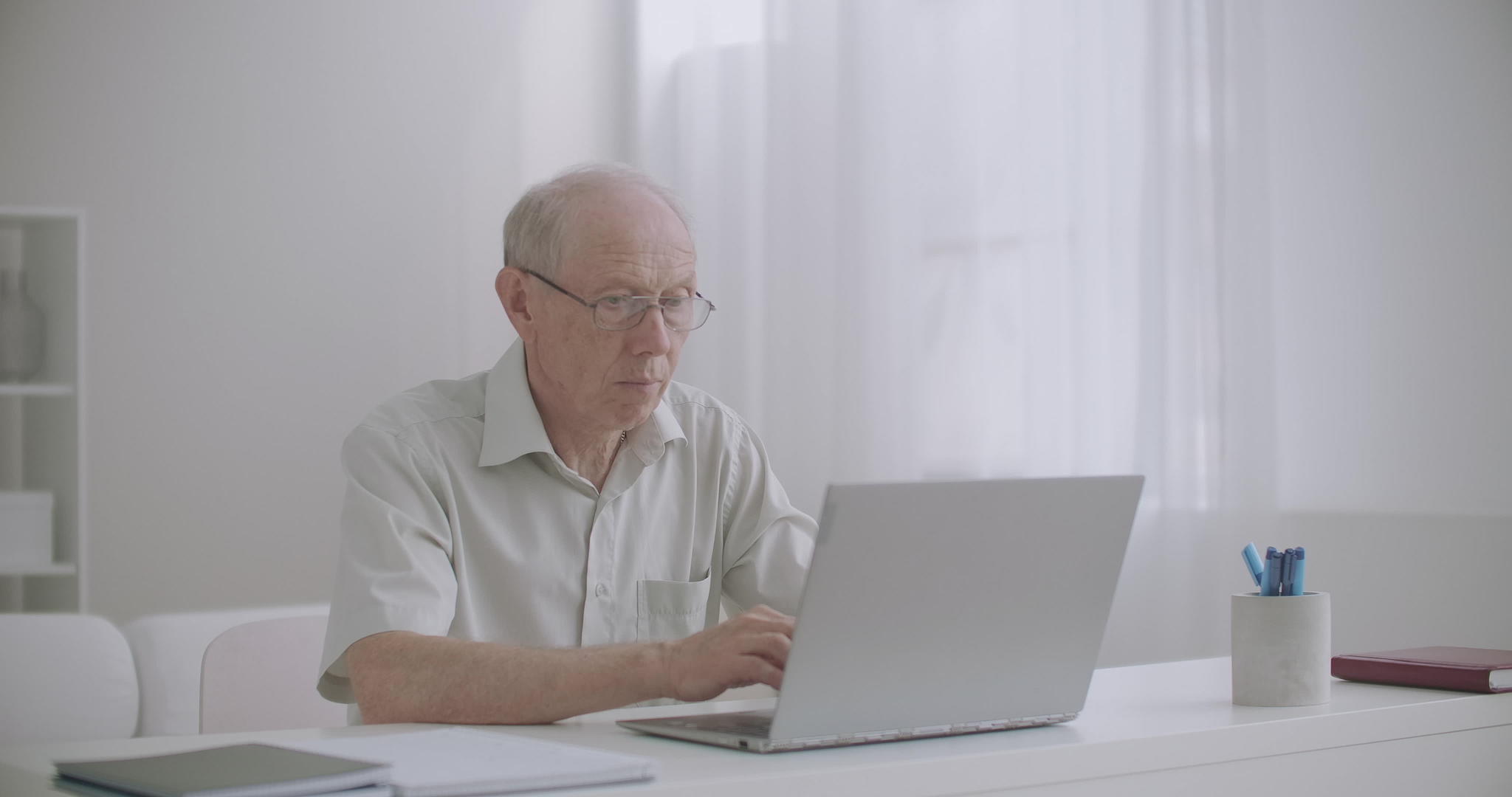 老年男性自由职业者在家用笔记本电脑工作老作家在写作视频的预览图
