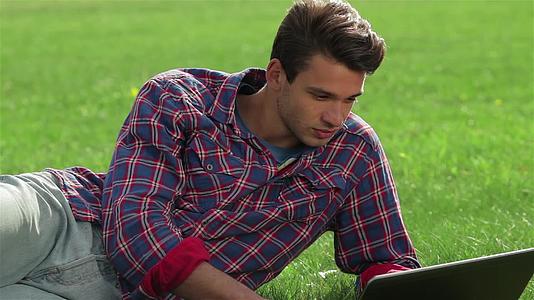 男人用笔记本电脑在花园里休息视频的预览图