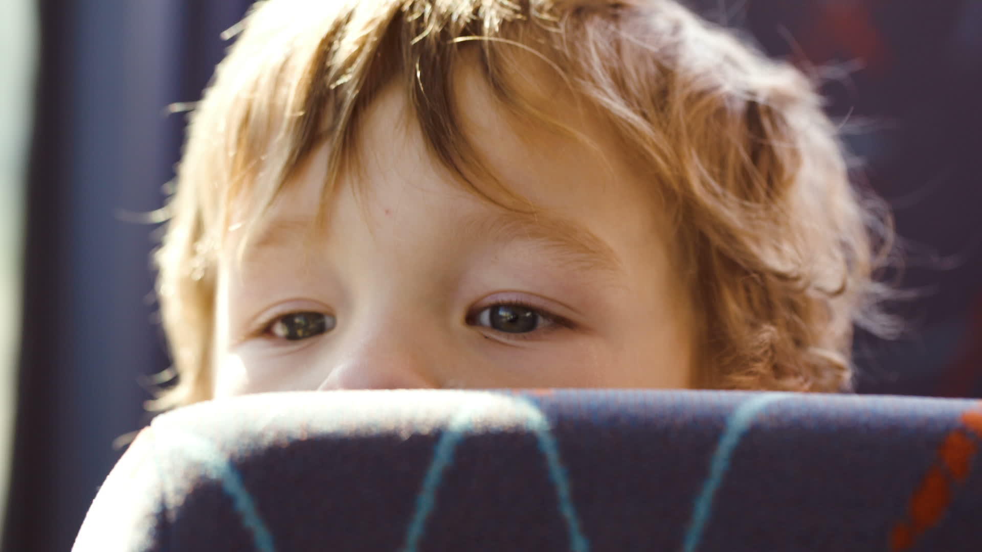 小男孩坐在公共汽车的座位后面视频的预览图
