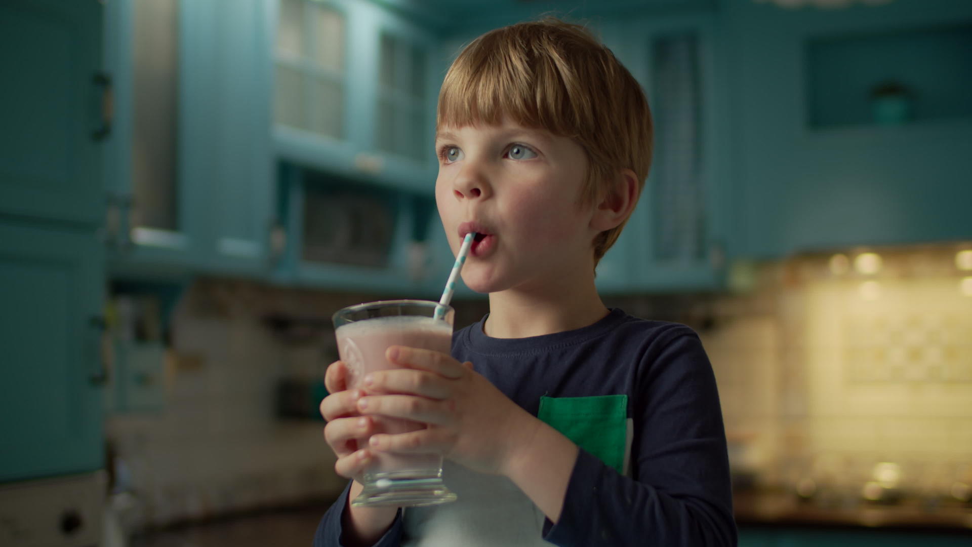 金发学龄前男孩喜欢在蓝色厨房喝白莓冰淇淋视频的预览图