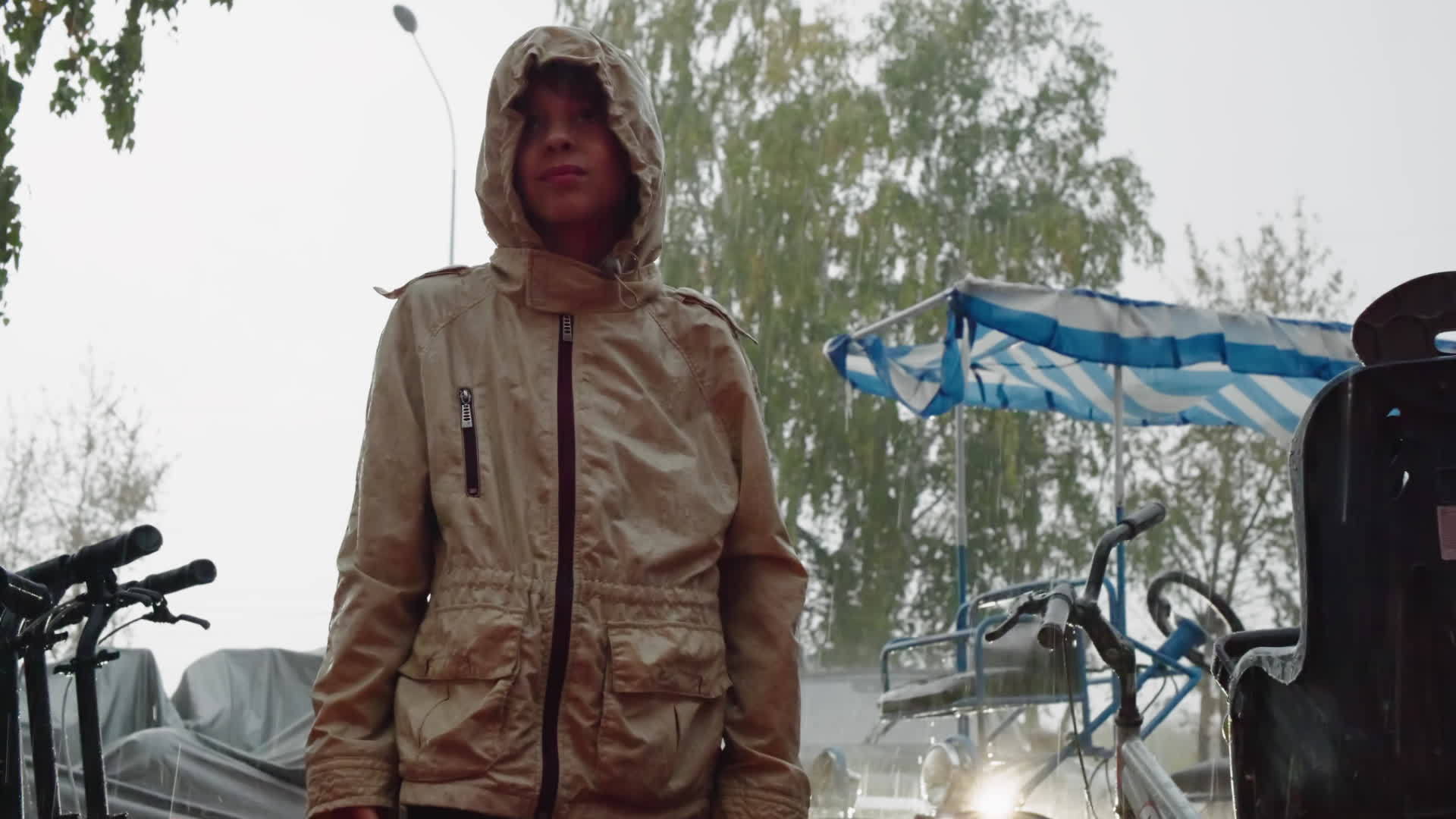 夏雨下雨穿着连帽夹克的年轻肖像男孩站在城市汽车视频的预览图