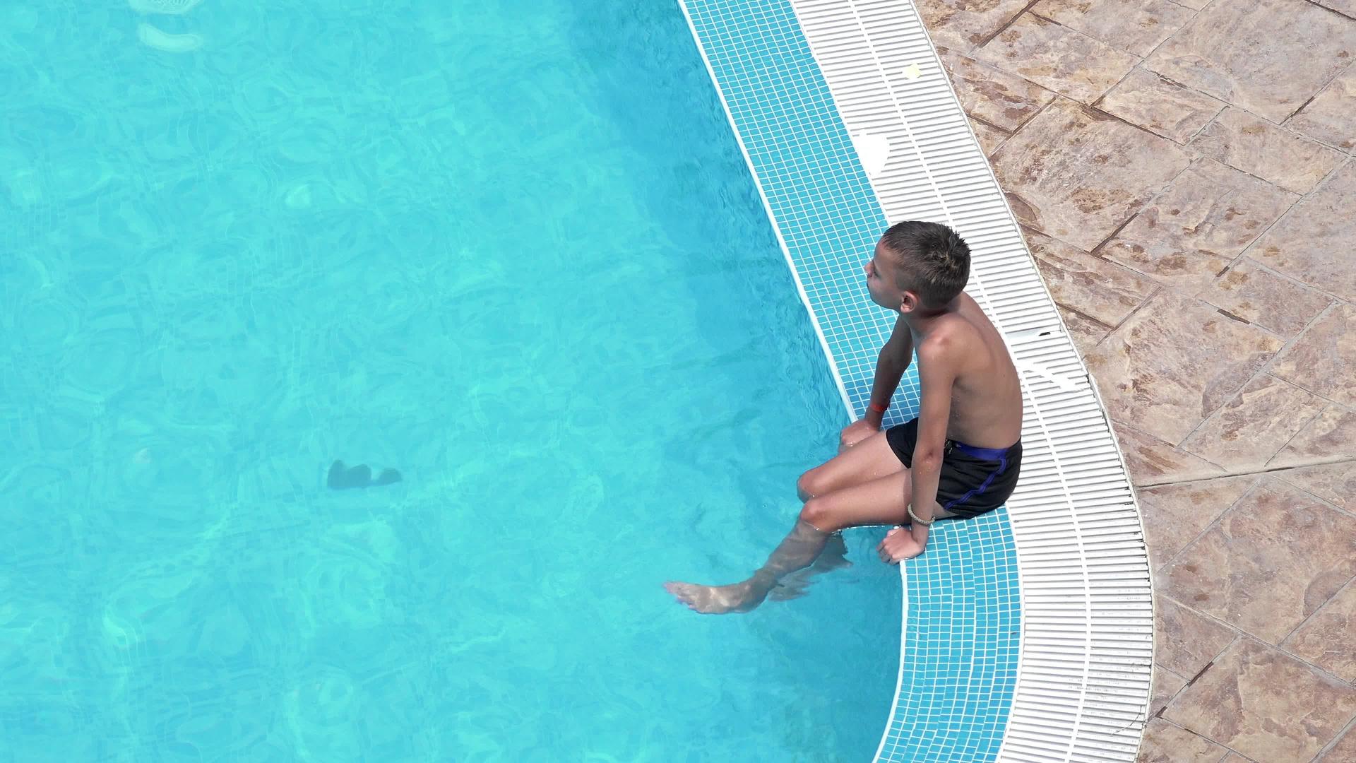 英俊的男孩在游泳池里放松视频的预览图
