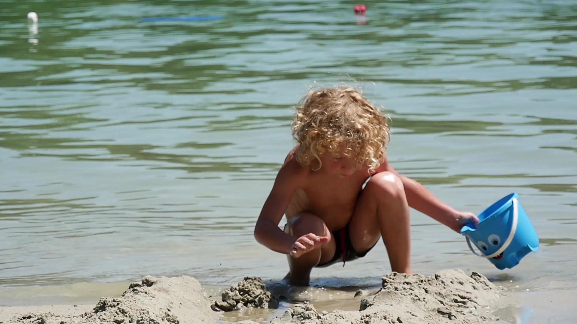 金发小男孩在海滩上玩耍视频的预览图