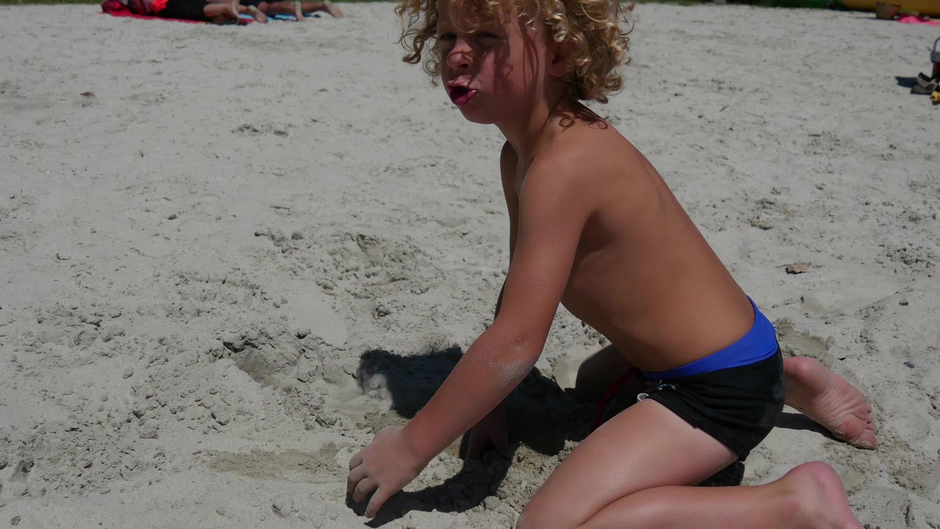 金发小男孩在海滩上玩耍视频的预览图
