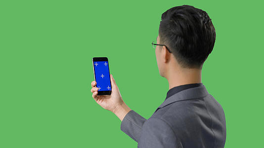 4k绿幕蓝幕合成男性看手机视频的预览图