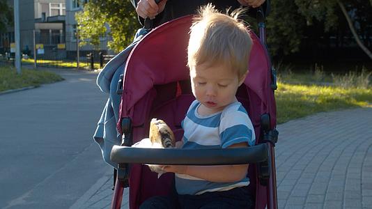 小男孩骑着婴儿车吃包子视频的预览图
