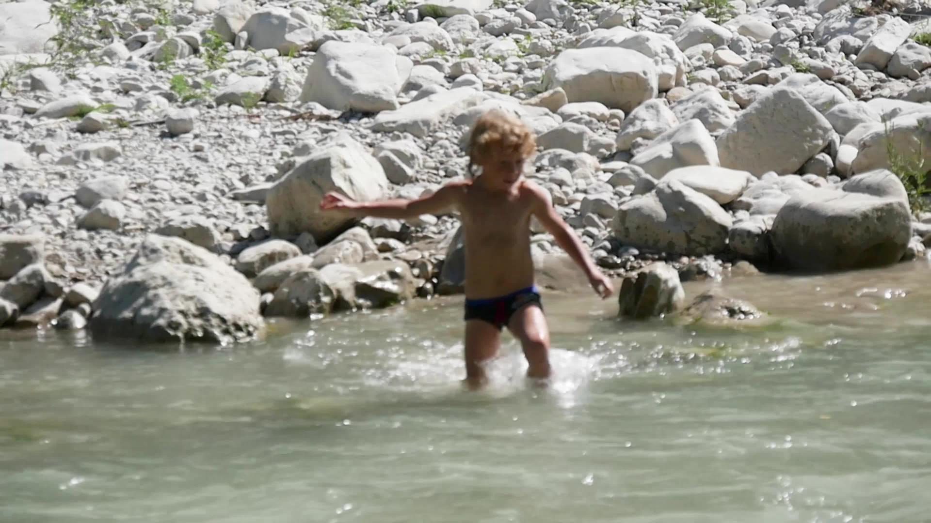 小金发男孩在河里玩耍视频的预览图