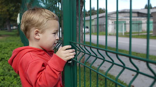 小男孩在铁丝网的栅栏里视频的预览图