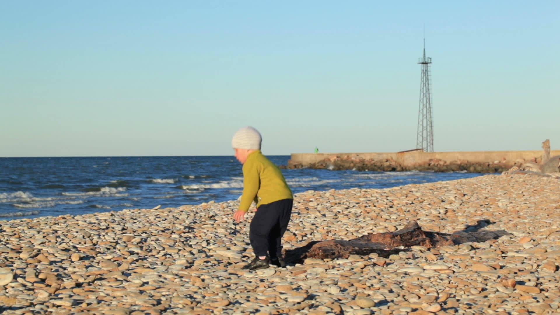 小男孩在小石头海滩上视频的预览图