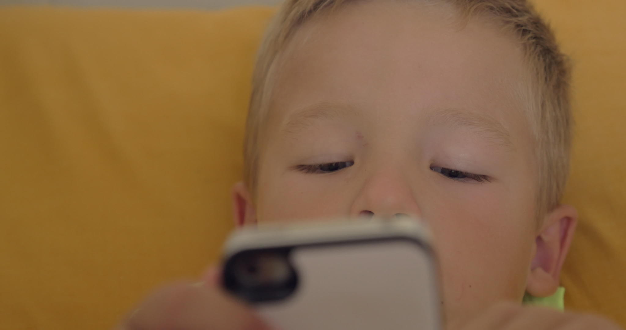 小男孩在智能手机上玩游戏近距离拍摄视频的预览图