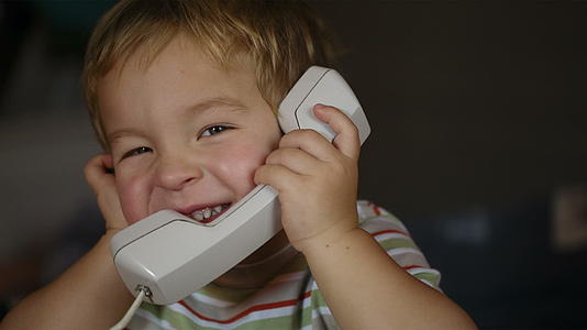 兴奋的小男孩通过电话收音机说话视频的预览图