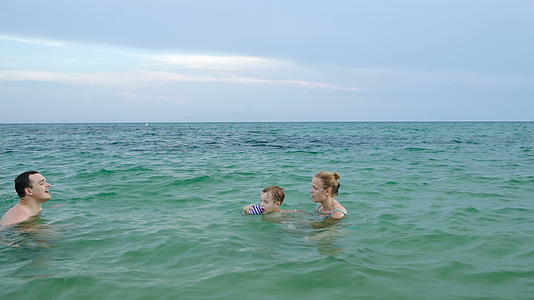 男孩在海里从母亲走到父亲视频的预览图