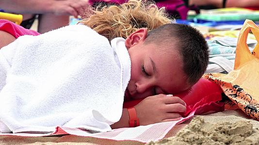 夏天一个英俊的昏昏欲睡的男孩在沙滩上被妈妈逗笑视频的预览图