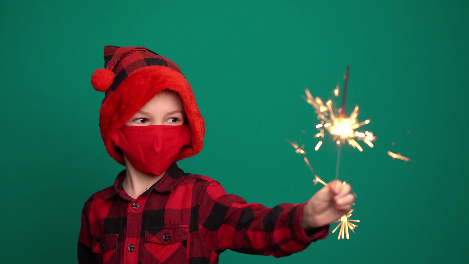 男孩戴着火花和圣诞帽戴着保护面具视频的预览图
