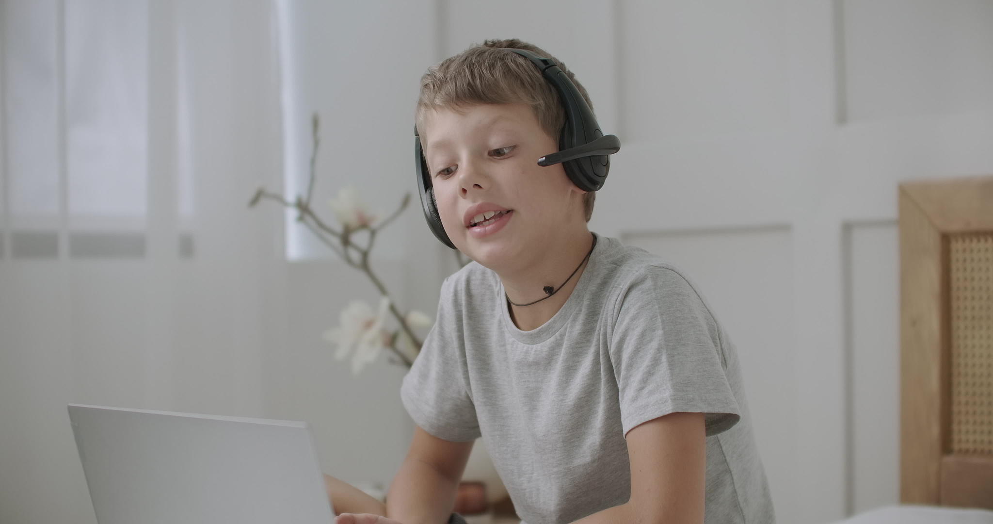 小男孩通过在线视频电话与某人交谈并使用笔记本电脑使用互联网视频的预览图