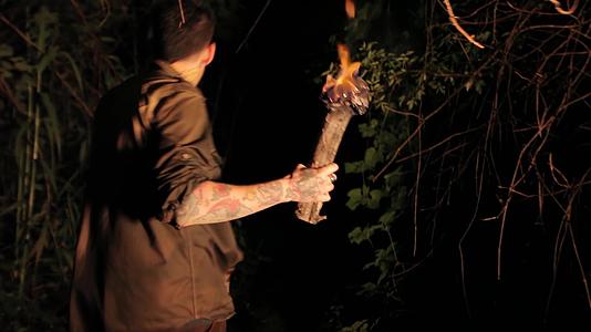晚上男孩手里拿着火炬3在树林里视频的预览图