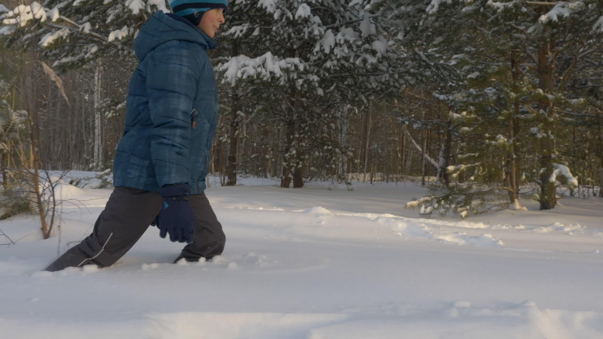 童年快乐的青少年在冬天的森林里走过雪冬天的活动视频的预览图