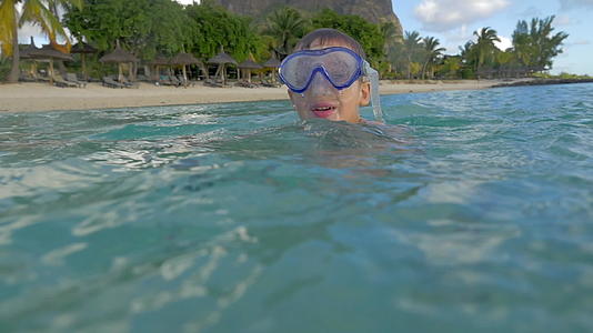 小男孩戴着浮潜面具在印度洋游泳并拍照视频的预览图